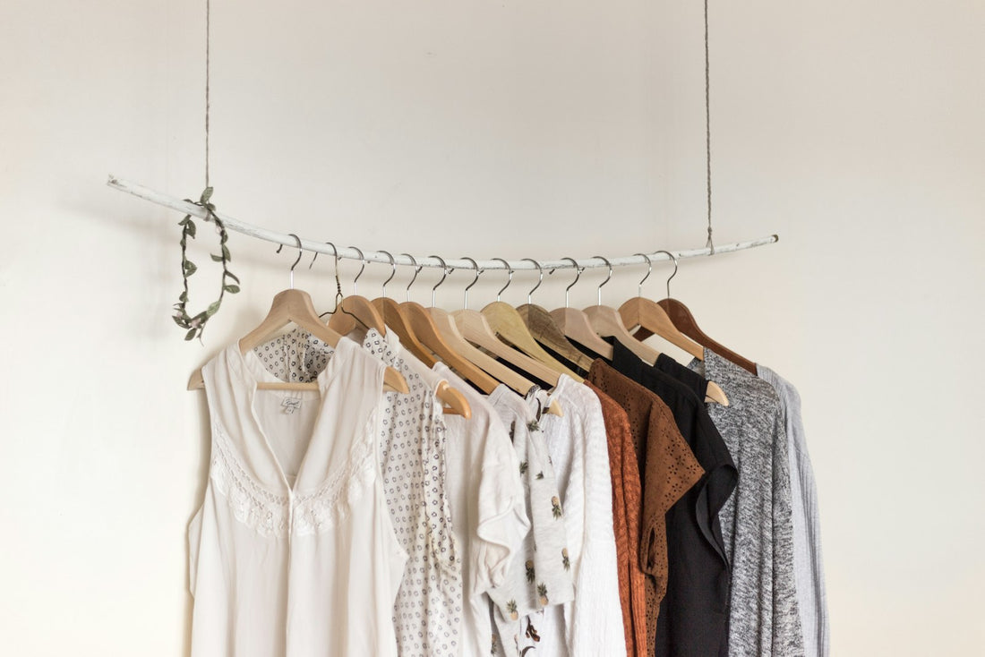 Capsule été — t-shirts blancs alignés sur cintres minimalistes